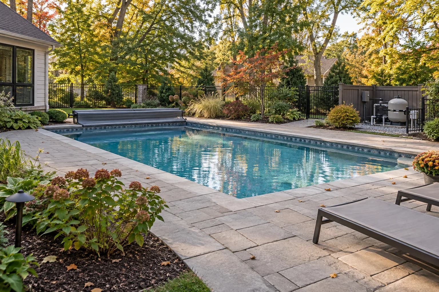 Midwestern backyard pool concept with deciduous planting, fitted cover, drainage, and seasonal equipment access